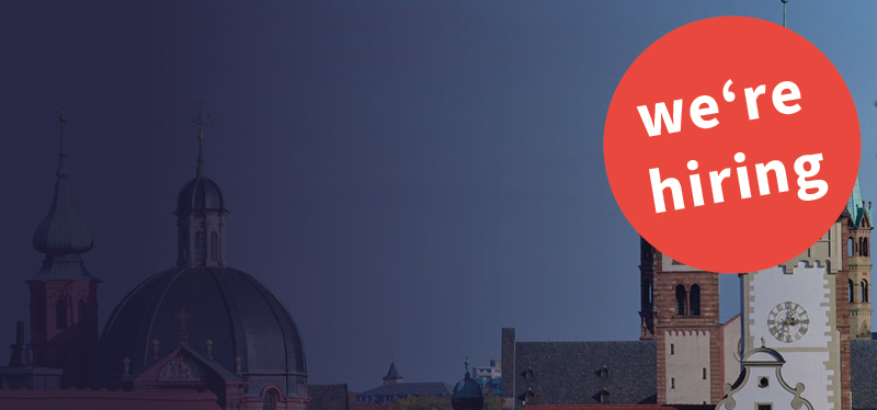 Verlinkung zur Meldung, die Grafik zeigt die Dächer von Würzburg und einen roten Kreis mit dem Text: "We're hiring"