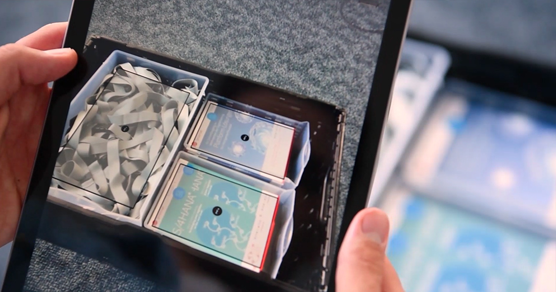 Auf diesem Bild wird Augmented Reality auf dem Tablet angewandt, um eine Handling Unit zu identifizieren:Das Kamerabild des Tablets wird um die Systeminormationen ergänzt: Informationen zu den Objekten werden optisch auf eben diese Objekte gelagert.