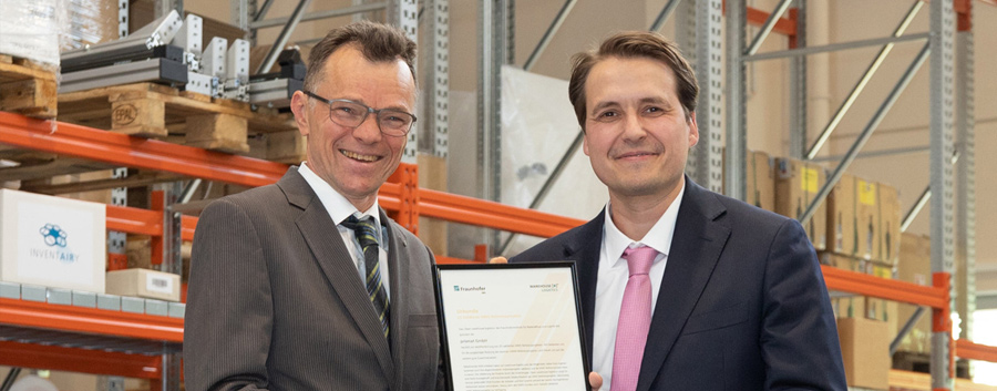 Auf diesem Bild ist die Übergabe des goldenen Signets von warehouse logistics an prismat zu sehen.