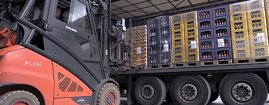 Auf diesem Bild ist die Ladefläche eines Lastkraftwagens zu sehen, die von einem Stapler mit Paletten beladen wird.