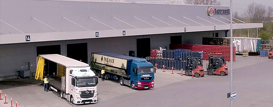Dieses Bild zeigt eine Luftaufnahme von Warenausganstoren, an denen LKWs stehen.
